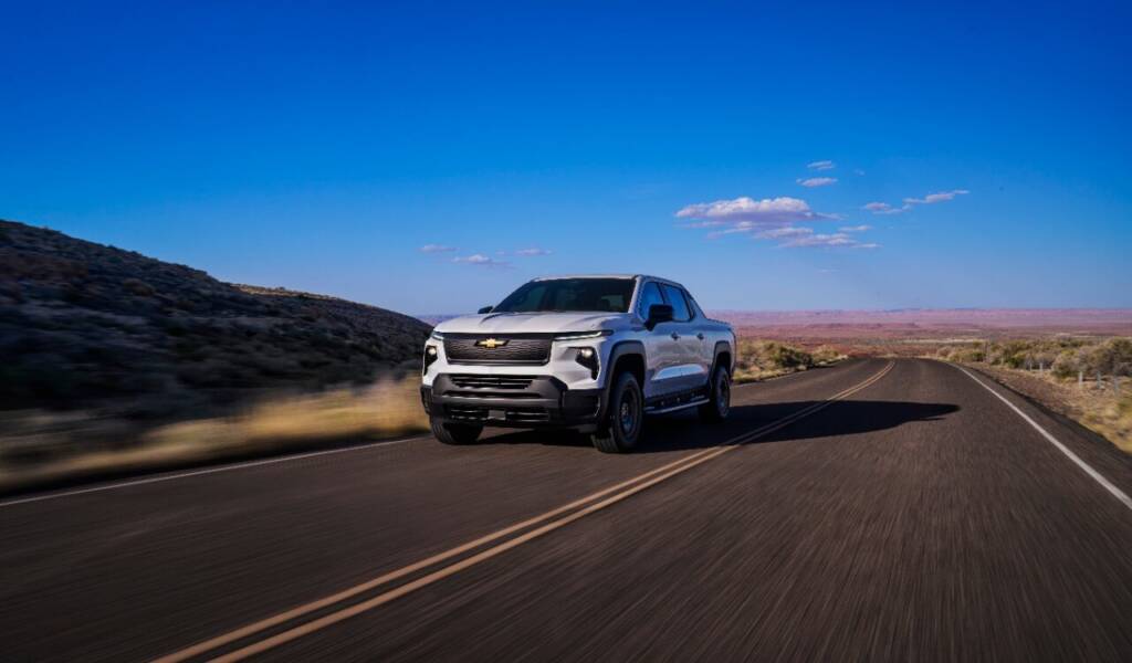 2024 Chevrolet Silverado electric vehicle driving down an open road