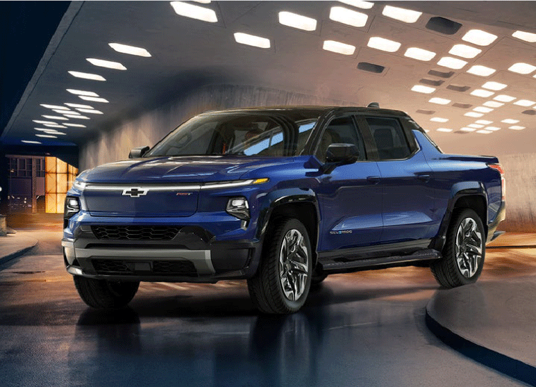 A blue pickup truck in a modern, illuminated tunnel with reflective surfaces.
