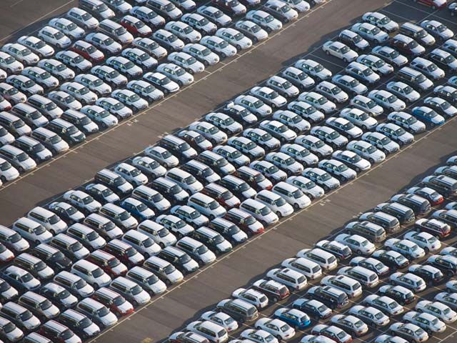 Aerial view of a large parking lot filled with rows of parked cars.