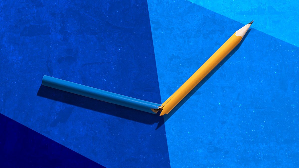 A yellow pencil is broken in two, forming a checkmark shape on a blue textured background.