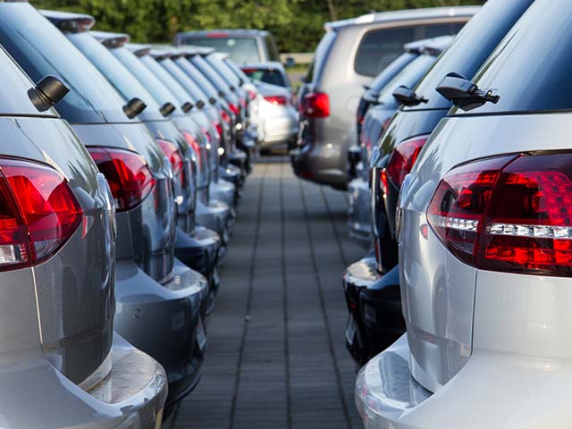Rows of parked silver cars lined up closely in a lot.