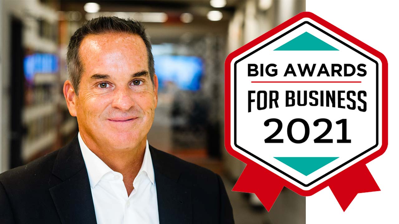 Smiling man in a suit next to a "Big Awards for Business 2021" badge.