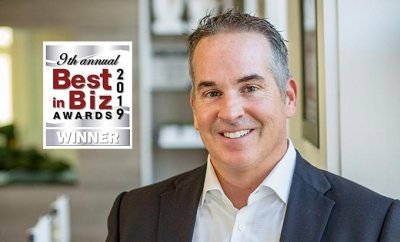 Smiling man in a suit next to a "Best in Biz Awards 2019 Winner" logo.
