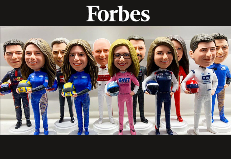Bobblehead figures of racing drivers with oversized heads in colorful suits under a Forbes banner.