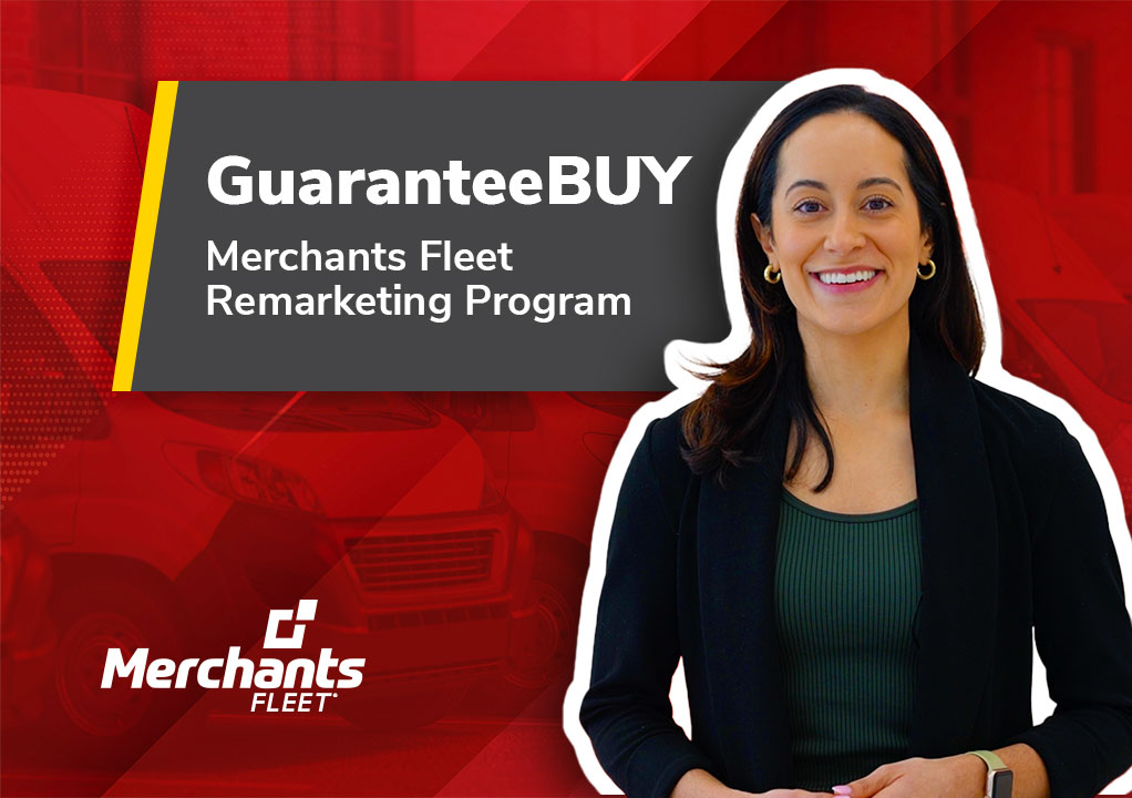 A person smiling, standing next to a sign that says "GuaranteeBUY Merchants Fleet Remarketing Program.