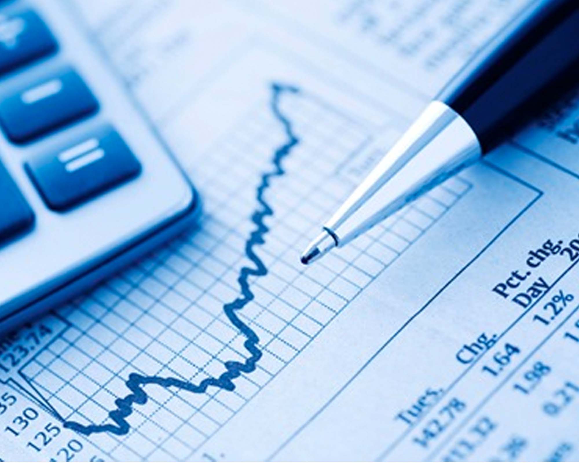 Calculator, rising graph on paper, and pen, symbolizing financial analysis or business growth.