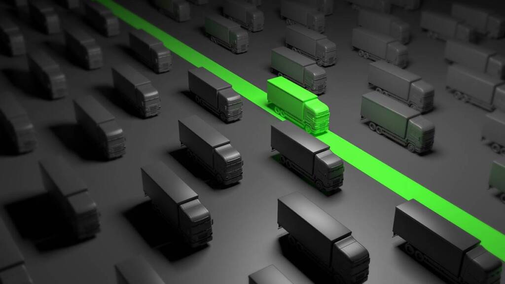 Rows of gray trucks on a road with one highlighted in green, symbolizing standing out or leadership.