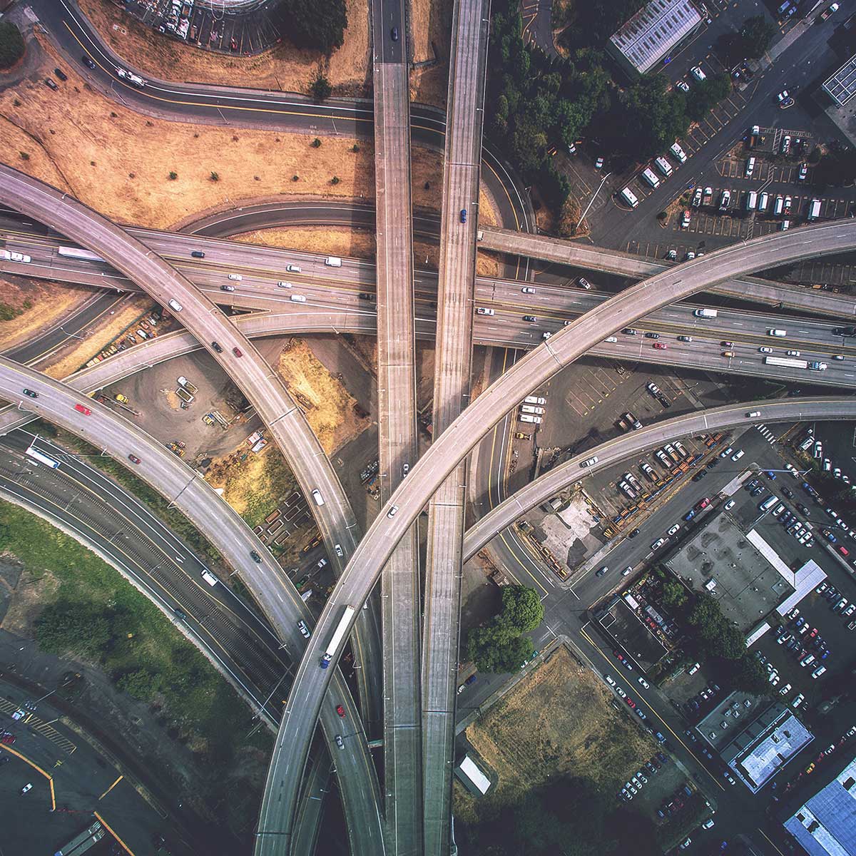 Aerial view of a complex highway interchange with multiple overpasses and traffic in an urban area.