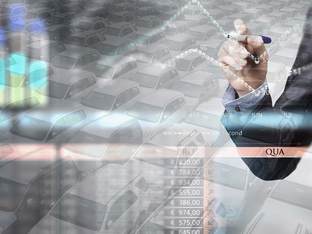 Person drawing a chart overlay on a background of parked cars and financial data.