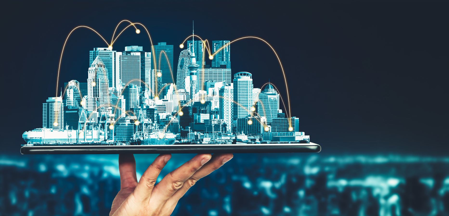A hand holds a tablet projecting a futuristic cityscape with illuminated network connections.