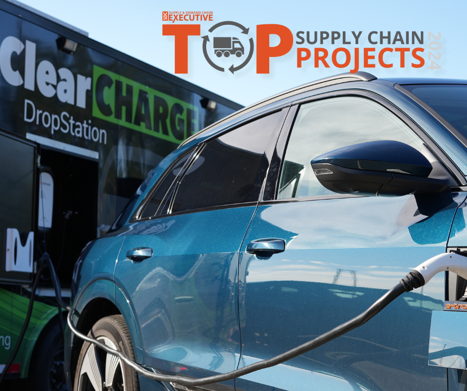 Electric car charging at a station with "Top Supply Chain Projects 2024" text on a building in the background.