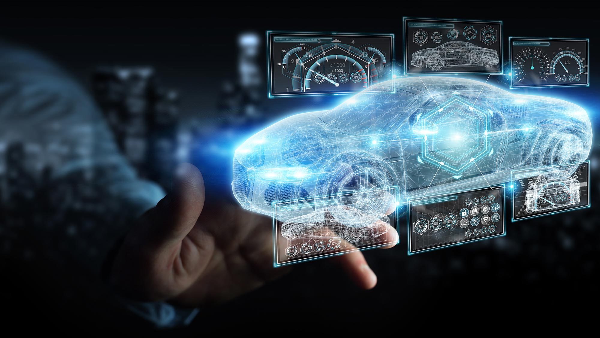 A holographic car model with digital dashboards is projected in front of a person's hand.