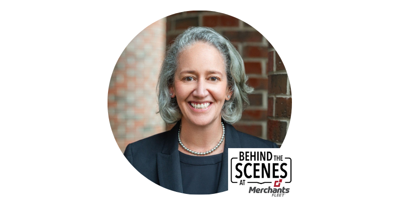 Smiling person with gray hair, wearing a dark blazer, in front of a brick wall. "Behind the Scenes at Merchants Fleet" logo present.