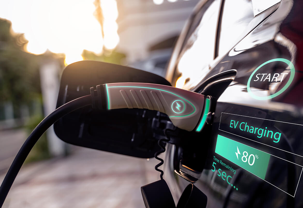 Close-up of an electric car charging with a cable; digital display shows charging status at 80% complete.