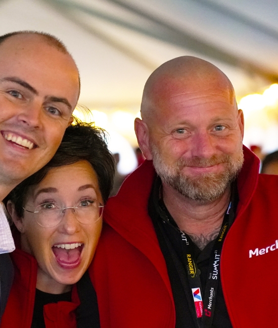 three merchants team members smiling in a group.