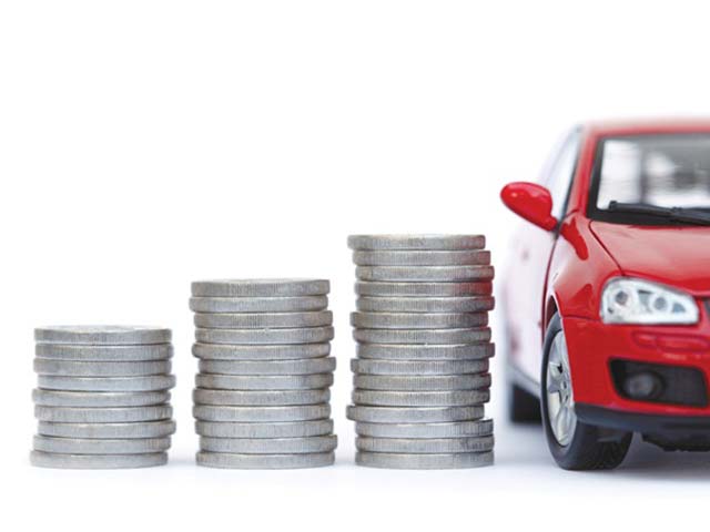 Stacks of coins increasing in size next to the front of a red toy car on a white background.