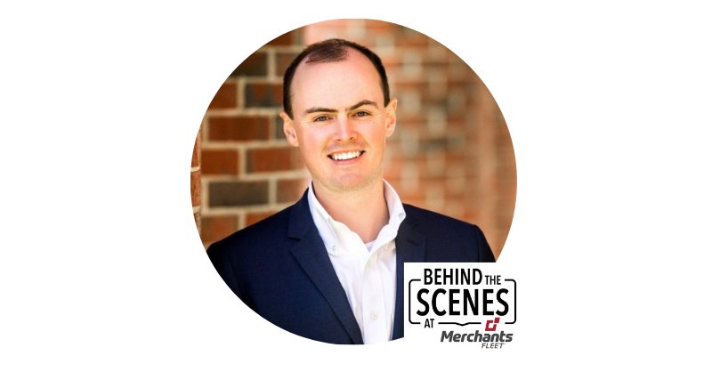 Smiling person in a suit stands in front of a brick wall. Text: "Behind the Scenes at Merchants Fleet.