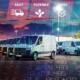 A fleet of vans in a lot with fast, flexible, easy icons above, overlaid with graphs and city lights at dusk.